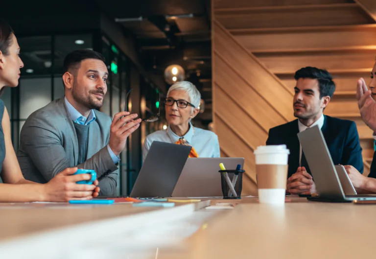 People talking in a professional setting around a table