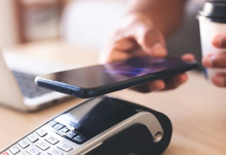 Someone tapping their phone on top of a payment terminal